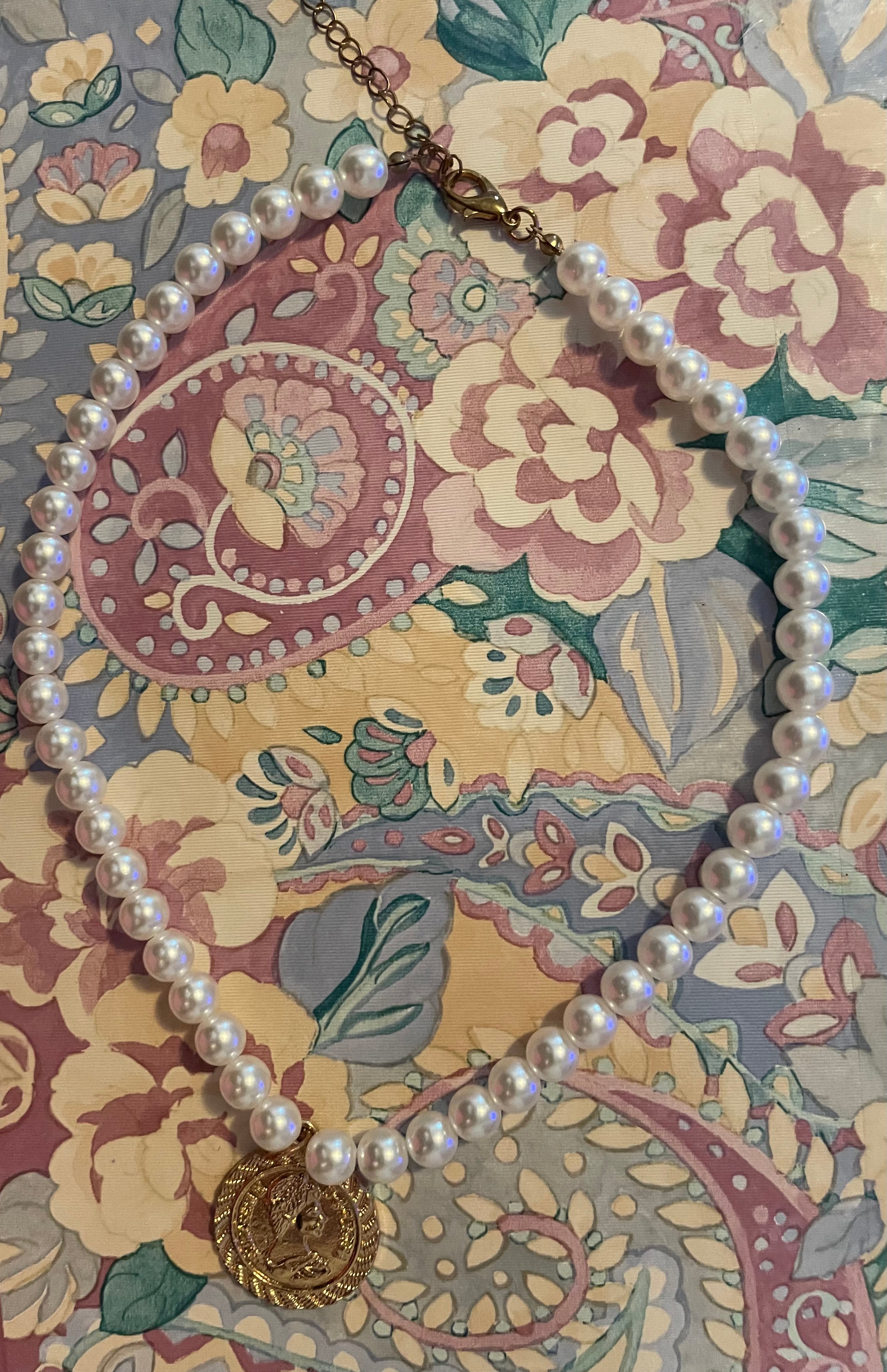 Pearl looking with Elizabeth the Second coin